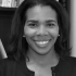 A Black woman with shoulder-length straight hair smiles at the camera.