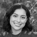 A black and white image of Fernanda, a young woman with dark shoulder-length hair. She is smiling at the camera.